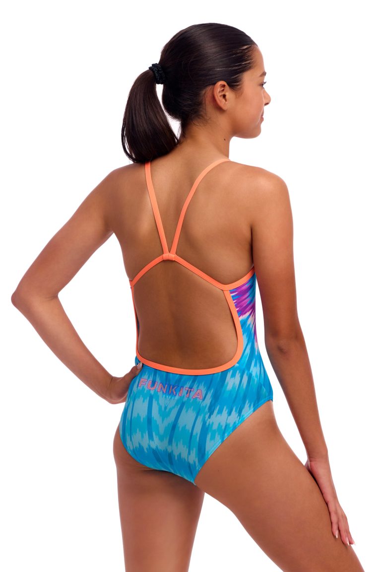 En kvinde står med ryggen til kameraet iført Funkita Birdie Bird - Single Strap badedragt med blåt og hvidt mønster, orange racerback-strop og "FUNKITA" trykt på den nederste del af ryggen.