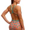 En kvinde står model til Funkita Stars Below - Single Strap-badedragt med koralfarvet bund med blå søstjerner og blå stropper, mens hun smiler med en hånd på hoften mod en hvid baggrund.