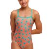 En kvinde smiler mod en hvid baggrund iført Funkita Stars Below - Single Strap - Damer badedragt i ét stykke med koralfarvet bund med turkise stjernemønstre, tynde skulderstropper og en firkantet halsudskæring.