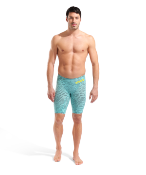 En mand står og kigger fremad iført Arena Powerskin Carbon-AIR² Open Back LtD (Water Maze) swim jammers med et lyseblåt geometrisk mønster og gult logo på en almindelig hvid baggrund.